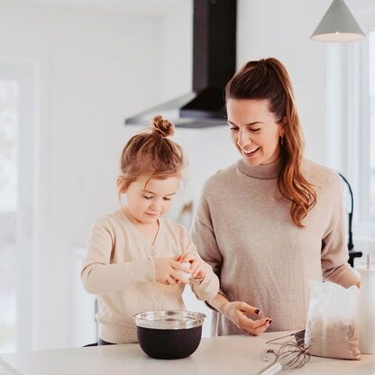 Una madre y su hija pequeña hornean juntas en la cocina.