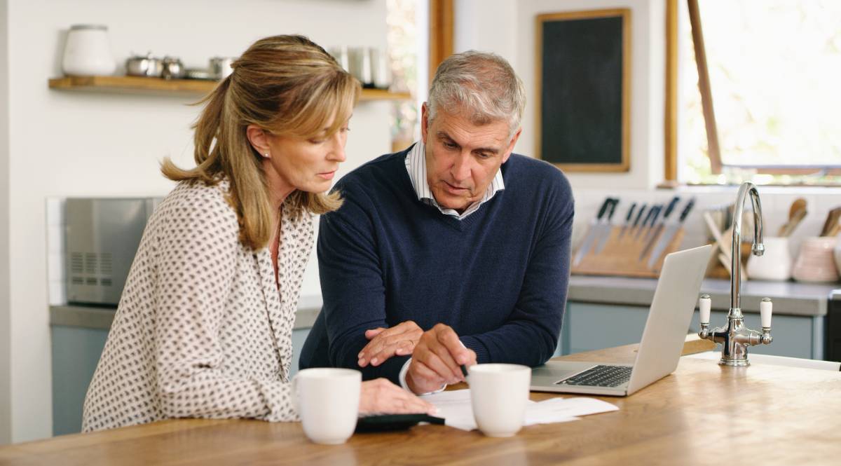 Man and woman looking at estate tax documents at a table in their home