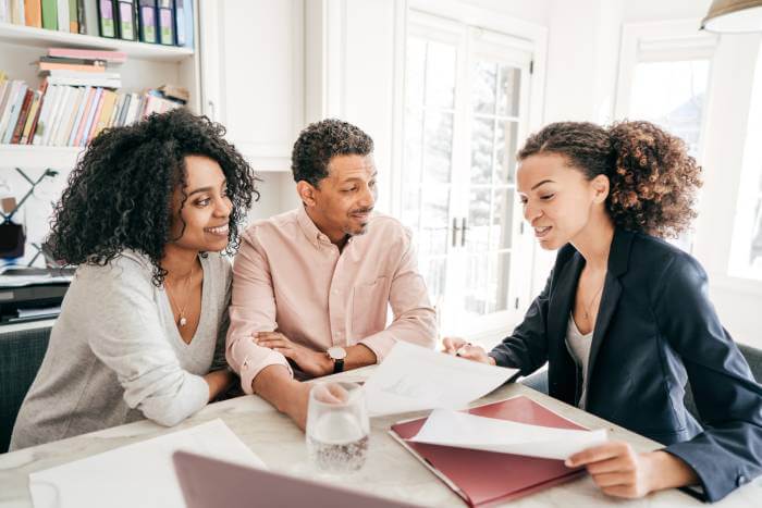 Medical Power of Attorney review by college coed and her parents while sitting at a home table.