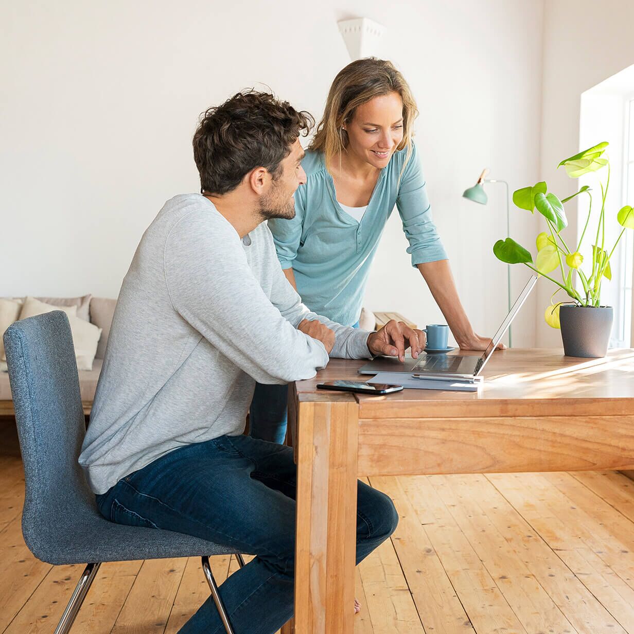 Couple working at their home business at a desk with a laptop computer.