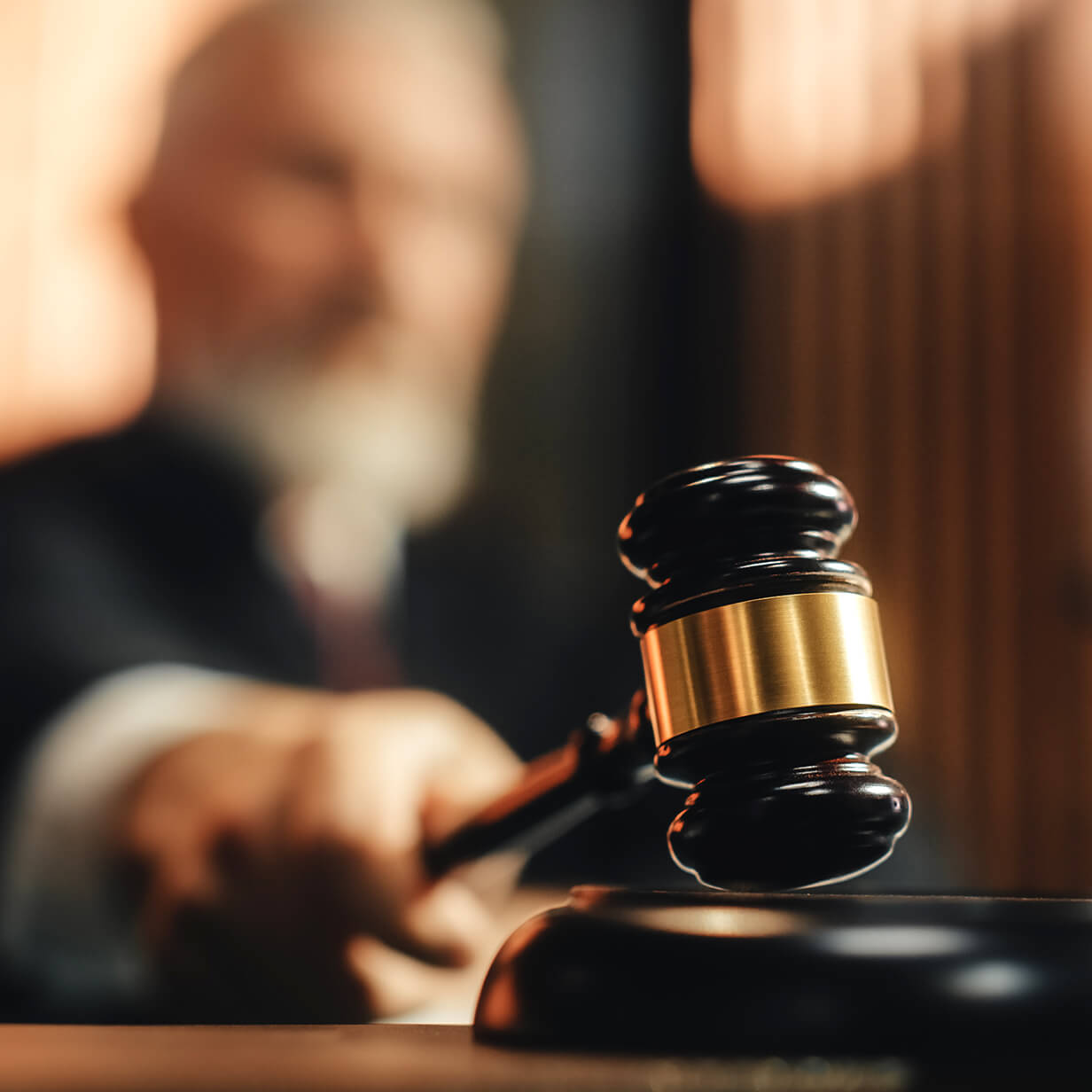 Judge in a courtroom usng a gavel.