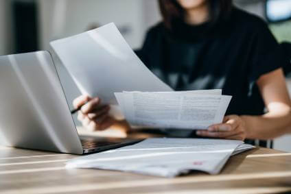 A housing market buyer reviewing home buying legal contracts and documents.