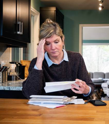 Woman looking at document and worried about car repossession.