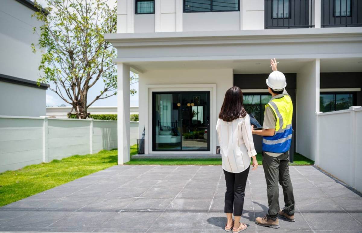 Woman talking to a home contractor outside of her house.