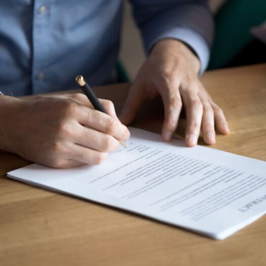 Un hombre firmando un contrato.