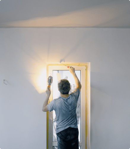 Hombre pintando y reparando una vivienda de alquiler