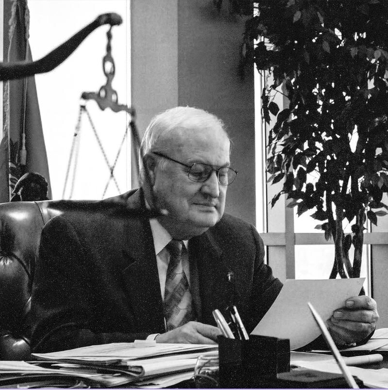 Harland Stonecipher, fundador, presidente y director ejecutivo de Pre-Paid Legal Services, Inc., trabajando en su escritorio.