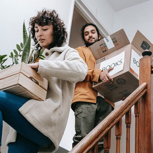 Hombre y mujer cargando cajas mientras se mudan de una vivienda de alquiler.