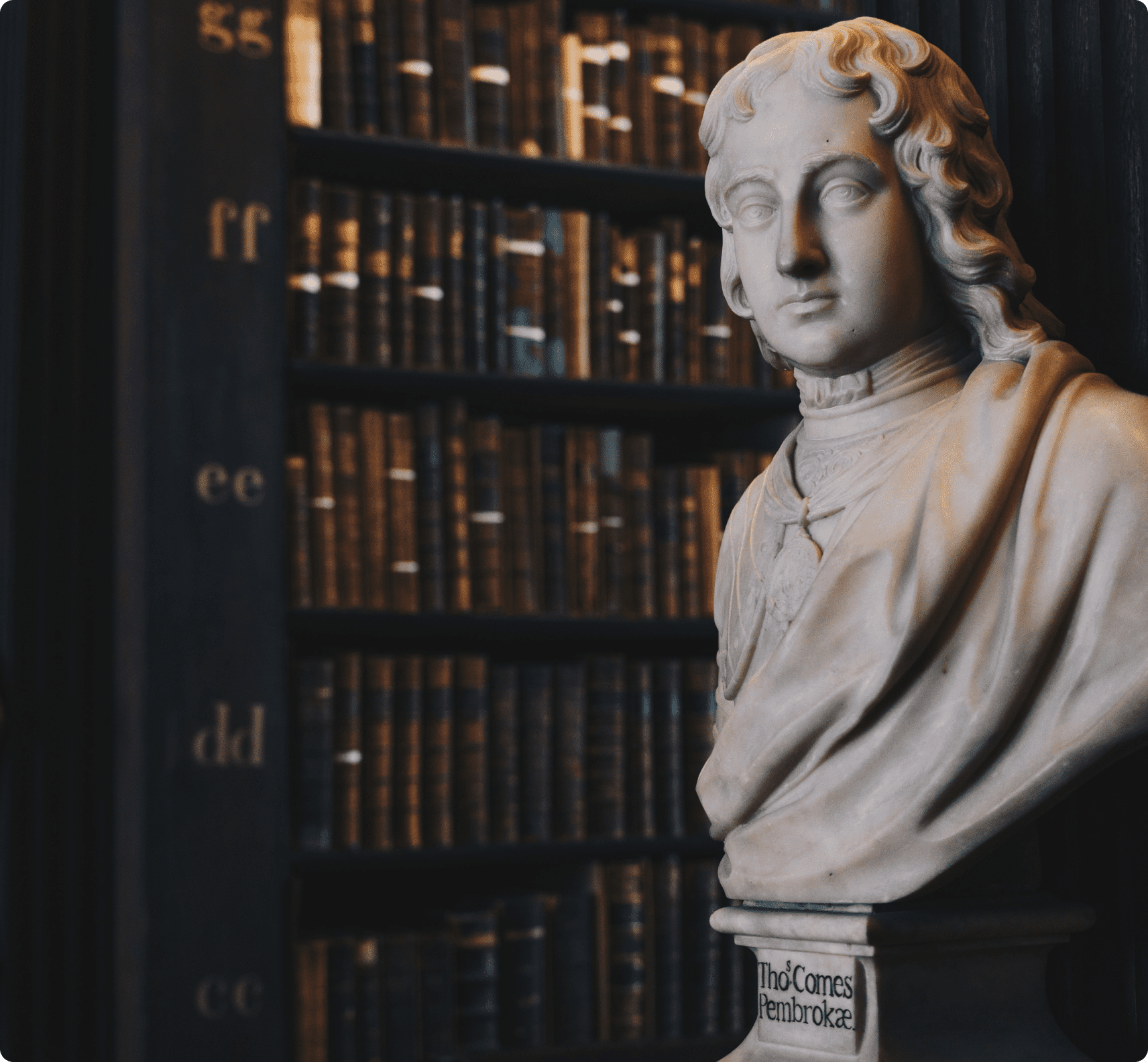 Una estatua de un abogado histórico en una biblioteca jurídica llena de libros en estanterías.