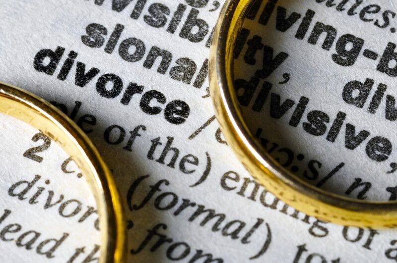 Definición de divorcio en el diccionario junto a 2 alianzas de boda