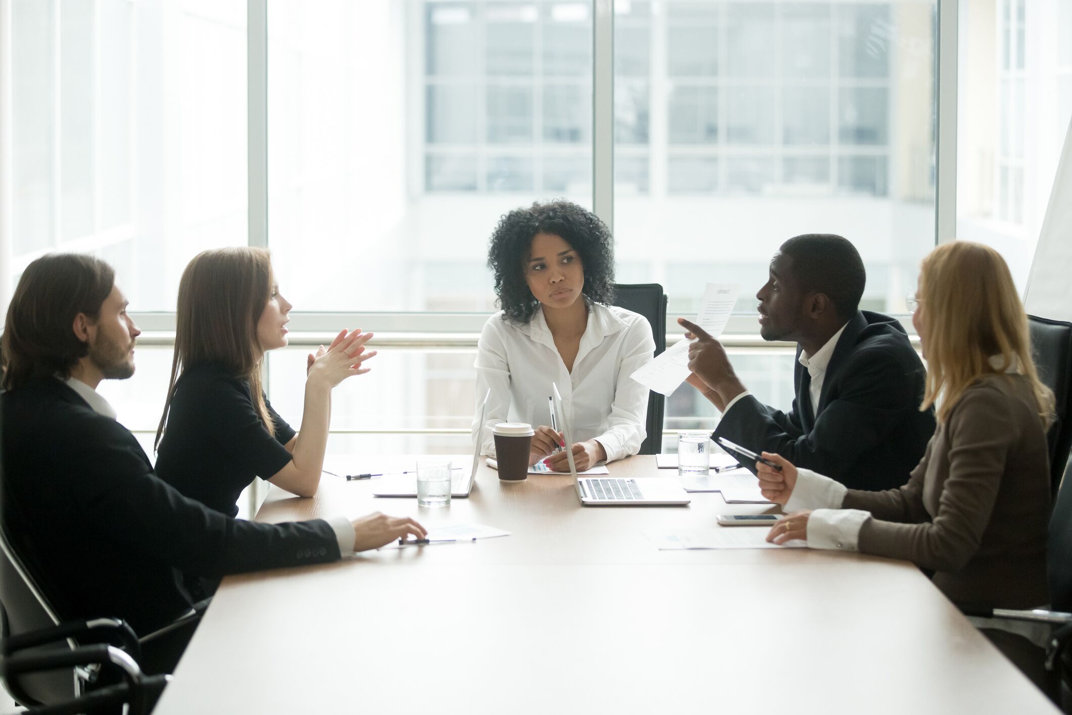 Business dispute being discussed by 5 people in a conference room