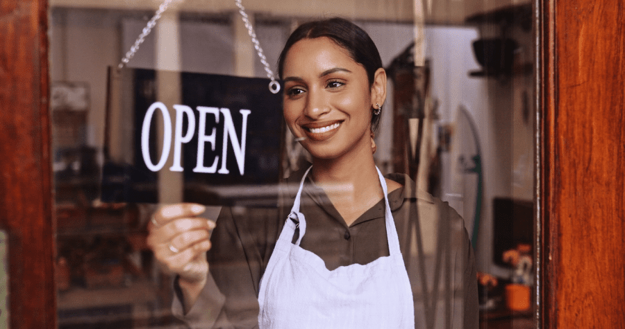 Employee in a shop flipping a closed sign to open