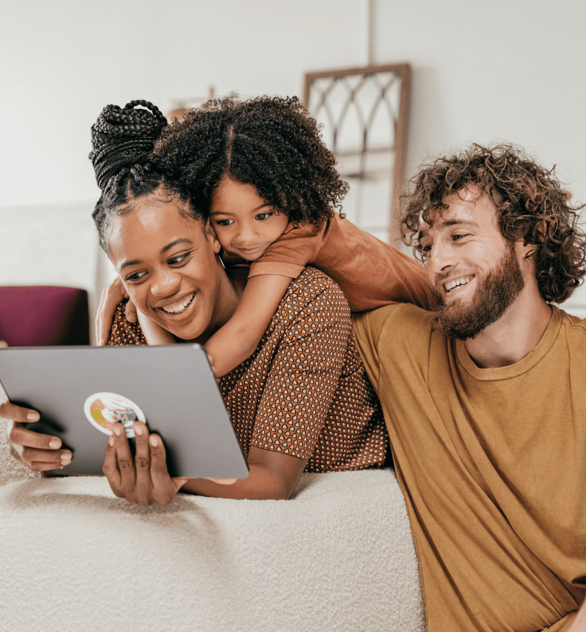 Madre, hijo y padre sonrientes utilizando una tableta informática para crear un testamento.
