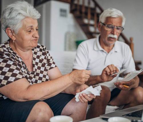 Elderly couple reviewing receipts after experiencing elder abuse.
