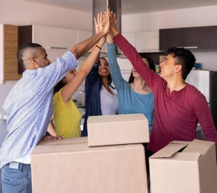5 college students doing a high 5 as they move into their rented apartment.