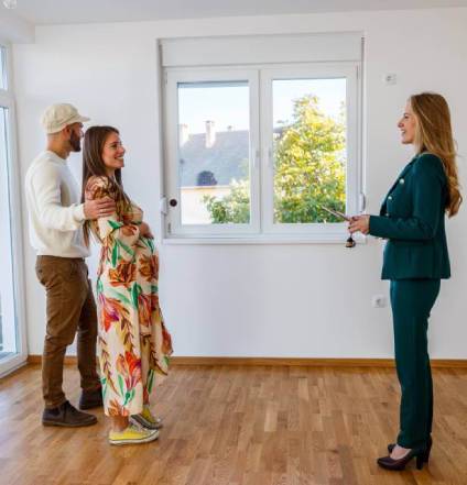 Home buyers in discussion with realtor as they view a property.