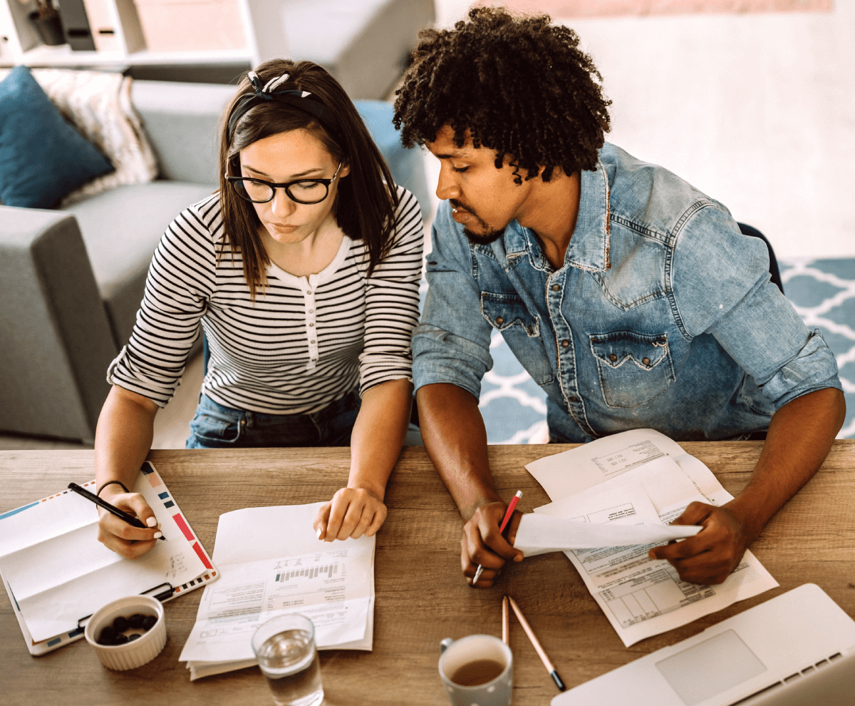 A young couple reviewing documents as they do estate planning.